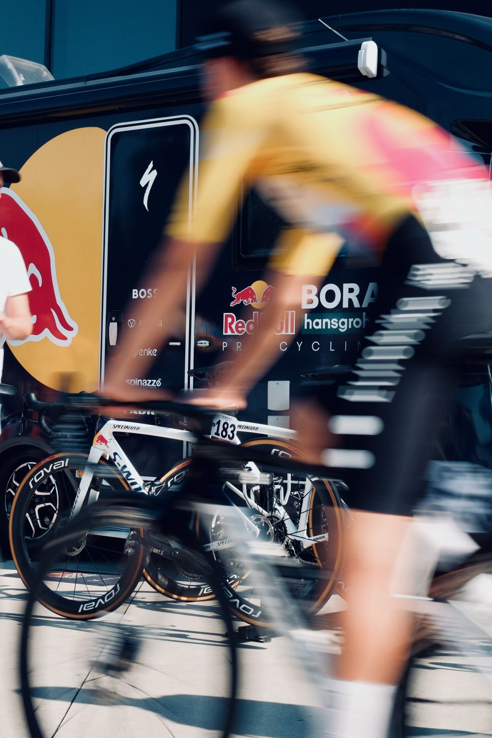 Coureur passant devant un bus d'équipe, flou de mouvement
