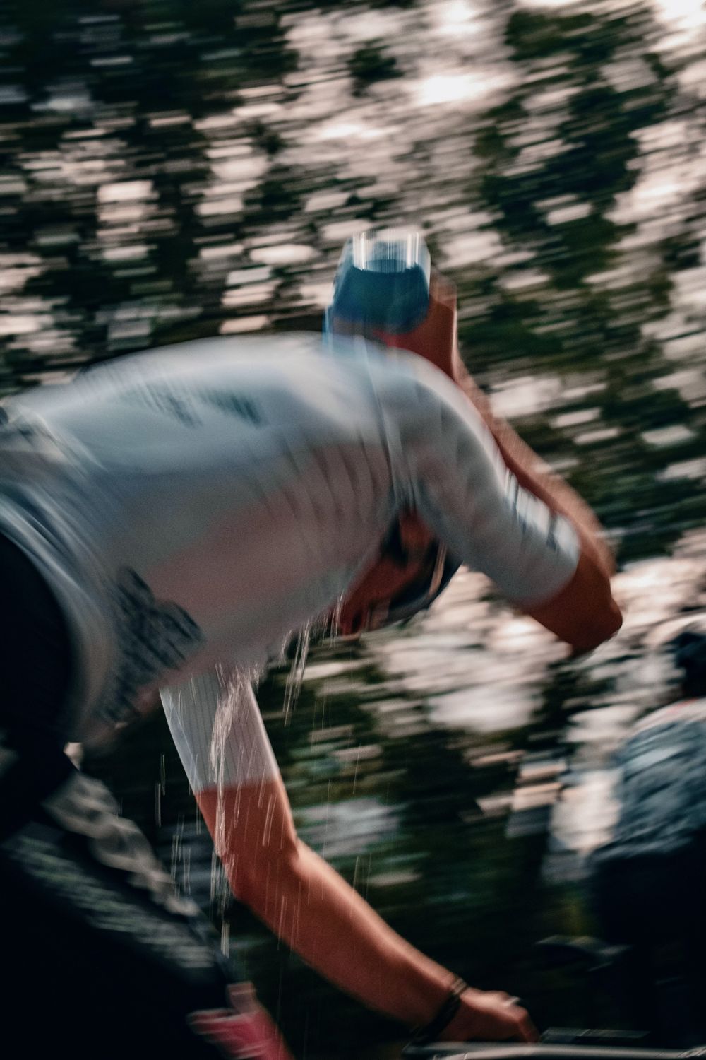 Coureur s'aspergeant d'eau en pleine course, flou de mouvement